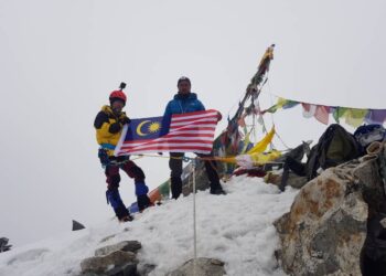 MUHAMMAD Syahrulnizam Mohd Noor (kiri) bersama Keshab Jung Thapa mengibarkan Jalur Gemilang di puncak Gunung Yala setinggi 5,520 meter. - UTUSAN
