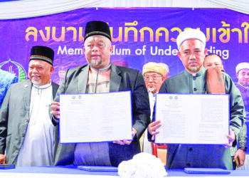 NIK Hazani Nik Mohamad (dua, kiri) dan Mohd. Suwari Hassan (kanan) menunjukkan MoU antara GISBH dengan pondok pengajian Pattani 
di Pejabat Pegawai Daerah Saiburi, baru-baru ini.