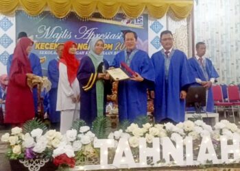 AHMAD MASLAN menyampaikan anugerah kepada seorang pelajar  cemerlang dalam peperiksaan Sijil Pelajaran Malaysia (SPM) 2022 pada Majlis Apresiasi SMK Benut, Pontian.
