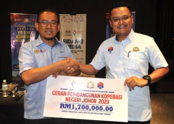 MOHD. HAIRI MAD SHAH (kanan) menyampaikan peruntukan berjumlah RM1.7 juta kepada Fadilah Salim  sempena Pelancaran Geran Pembangunan Koperasi Johor 2023 di Hotel Amansari, Iskandar Puteri.