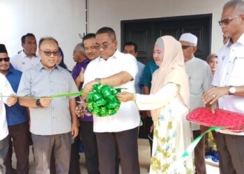 NORHASHIMAH Ismail (dua dari kanan) melihat Menteri Besar, Datuk Seri Muhammad Sanusi Md. Nor memotong riben di hadapan rumahnya di Keda Kampung Sadek, Kupang, Baling.
