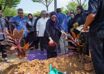 kilafairy menyiram air mawar di pusara ibunya,  Rohana Jalil  yang dikebumikan di Tanah Perkuburan Islam USJ 22 di  Subang Jaya semalam. – UTUSAN/MUHAMAD IQBA
