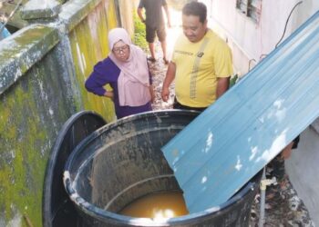 SHAHRIEZAN Yahya bersama isteri terpaksa menadah air hujan apabila bekalan air bersih terputus di Kampung Kubang Batang, Tumpat, Kelantan. - UTUSAN/ROHANA ISMAIL