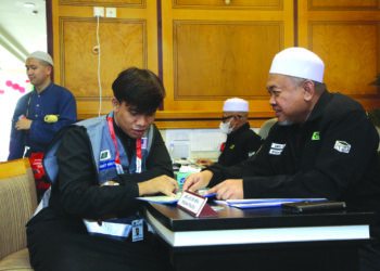 Muhammad Haqim Mohd. Farid (kiri) berbincang dengan salah seorang petugas haji untuk menjalankan tugas sebagai petugas maktab ketika ditemui di Hotel Fajer Al-Badee 5, Mekah baru-baru ini.