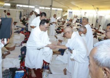 MOHD. Na'im Mokhtar (kiri) bersalaman dengan jemaah yang berwukuf di Arafah kelmarin.