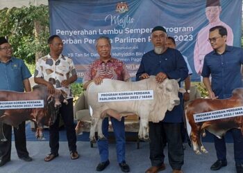 MUHYIDDIN Yassin (tengah) semasa Majlis Penyerahan Lembu Korban bagi Parlimen Pagoh di Bukit Pasir, Muar, Johor, hari ini.