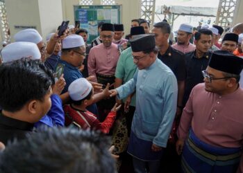 ANWAR Ibrahim bersalaman bersama jemaah selepas menunaikan solat Jumaat di Masjid Bandar Tun Hussein Onn. Turut sama, Amirudin Shari. - UTUSAN/FARIZ RUSADIO