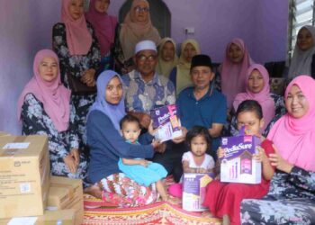 PENGERUSI Gabungan Masjid Felda Wilayah Jengka, Razak Daud  (tiga, kanan)  menyampaikan susu jenama PediaSure kepada Nur Ashikin Omar di Felda Kota Gelanggi, Jerantut baru-baru  ini. 
– UTUSAN/SALEHUDIN 
MAT RASAD