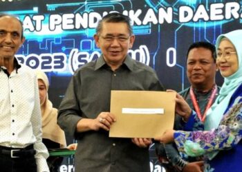 SALAHUDDIN Ayub menyampaikan baucer ITTV e-Learning Rahmah kepada salah seorang pengetua sekolah sempena Perhimpunan Bulanan, Apresiasi Pendidikan & Pelancaran ITTVe - Learning Rahmah di Kempas, Johor Bahru, hari ini. - UTUSAN/RAJA JAAFAR ALI