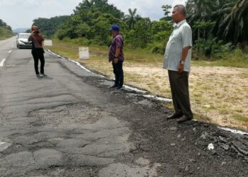 AHMAD Said (kanan) meninjau keadaan jalan  menghubungkan Kampung Ibok ke  Bandar Seri Bandi, Kemaman yang rosak, semalam. - UTUSAN/NIK NUR IZZATUL HAZWANI NIK ADNAN