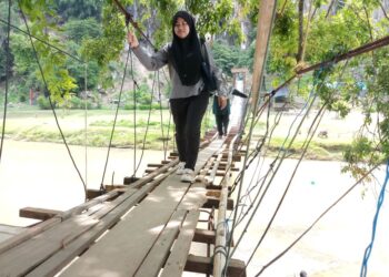 JAMBATAN gantung yang dibina oleh Mohd. Fauzi Abdullah menjadi daya tarikan pelancong di Kampung Lubuk Pedati, Baling. - UTUSAN/ NORLIA RAMLI