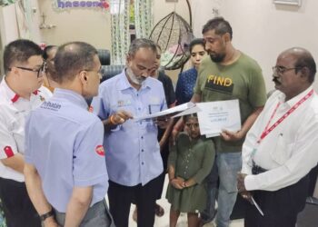 V. SIVAKUMAR (tengah) ketika menyampaikan faedah Perkeso kepada R.Chandran (dua dari kanan)  di Taman Desa Temiang, Seremban hari ini.-UTUSAN/NOR SHAFAWATI YUP.
