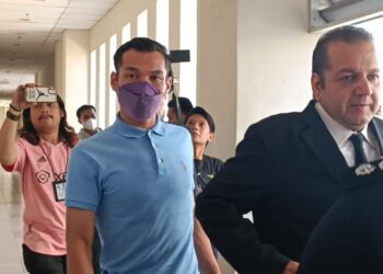 PEMAIN pertahanan Sabah FC, Mohd. Rizal Mohd. Ghazali (baju biru) ketika hadir untuk didakwa atas pertuduhan mencederakan dan merosakkan telefon bimbit teman wanitanya di Mahkamah Majistret Petaling Jaya. - UTUSAN/NUZULSHAM SHAMSUDIN