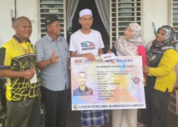 MUHAMMAD Syahril Saidi (tengah) menerima sumbangan daripada Noor Haslina di rumahnya, di Kampung Kandis, Bachok, Kelantan, hari ini.