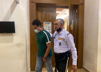 TERTUDUH di bawa keluar dari Mahkamah Khas Trafik Kuantan selepas pertuduhan dibacakan.  - UTUSAN/ DIANA SURYA ABD WAHAB