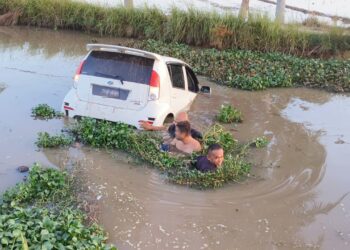 ANGGOTA polis terpaksa terjun ke tali air bagi membawa keluar suspek setelah kereta dipandunya terbabas di Kampung Alor Besar, Pendang.