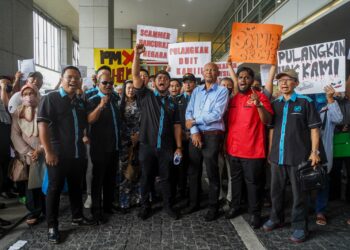 HISHAMUDDIN Hashim bergambar bersama mangsa ketika demonstrasi pelaburan haram di Menara SSM, KL Sentral. - UTUSAN/SHIDDIEQIIN ZON