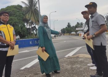 JUWAIRIYA Zulkifli (dua, kiri) bersama petugas JKR Daerah Kuala Selangor meninjau keadaan persimpangan Jalan Teluk Piah, Kuala Selangor, Selangor, hari ini.