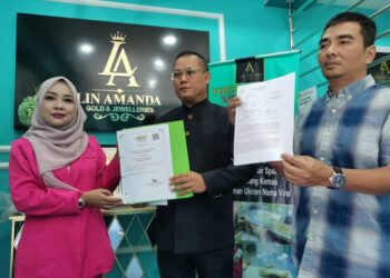 WAN Azman Fikri Wan Hussin (kiri) bersama peguam dan isterinya Roslinda Mohamad menunjukkan laporan polis yang telah dibuat berkait dengan fitnah ke atas mereka ketika ditemui pemberita di Kota Bharu, Kelantan hari ini.-UTUSAN/ROSALWANI CHE SOH