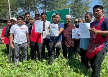SEBAHAGIAN peniaga menunjukkan notis arahan supaya berpindah di Pantai Bisikan Bayu, Semerak di Pasir Puteh, Kelantan hari ini. UTUSAN/TOREK SULONG