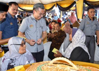 FAHMI Fadzil (tengah) beramah mesra dengan penerima pada Majlis Pra Pelancaran Komuniti Madani Peringkat Negeri Kelantan di Dewan Wawa, Jalan Kelochor, Kota Bharu, Kelantan hari ini.-UTUSAN/ROSMIZAN RESDI