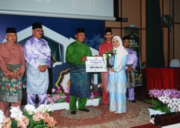RAHMAD Mariman menyampaikan hadiah RM5,000 kepada Siti Nabilah Zamri yang muncul juara hafazan al-Quran pada Majlis Tilawah dan Hafazan al-Quran Peringkat Kebangsaan 2023 di Auditorium Masjid Al-Azim, Bukit Palah, Melaka. - UTUSAN/AMRAN MULUP