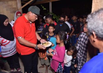 Mohd. Syahbuddin Hashim (dua kanan) menyantuni kepada penduduk Orang Asli di Pos Balar, Gua Musang, Kelantan.-UTUSAN/AIMUNI TUAN LAH