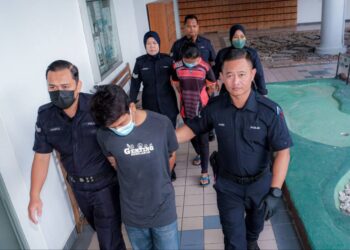 KEDUA-DUA tertuduh diiring keluar anggota polis selepas didakwa di Mahkamah Majistret dan Mahkamah Sesyen, Ayer Keroh, Melaka. - UTUSAN/SYAFEEQ AHMAD