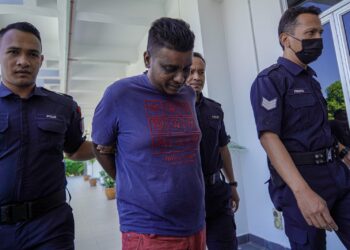 U.S. Divagaran dibawa oleh anggota polis ke Mahkamah Majistret Bandar Baru Bangi bagi menghadapi pertuduhan mencederakan seorang pekerja kedai serbaneka. UTUSAN/FARIZ RUSADIO.