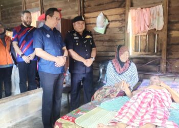 ROSLIN Hisham Abd. Hamid dan Maslan ketika menyantuni keluarga memerlukan pada Program Kesejahteraan Komuniti Malaysia Madani Peringkat Daerah Jelebu di Kampung Kuala Pah, Jelebu hari ini.-UTUSAN/NOR AINNA HAMZAH.