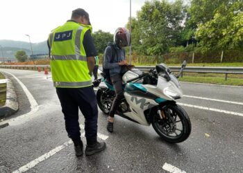 ANGGOTA JPJ memeriksa seorang penunggang motosikal pada Operasi Khas Sempena Hari Raya Aidiladha Tahun 2023 di Plaza Tol Ainsdale, Seremban hari ini.-UTUSAN/AFIFI HAFIZ MOHD. NOR.
