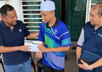 SYAIFUL Rizal Abdul Ghani (kiri) menyampaikan sumbangan kepada Muhammad Syahril Saidi sambil diperhatikan Pengurus Jabatan Komunikasi Korporat YBR, Mohamad Ghazali Zainal Abidin di Perumahan Myhome, Kendis Bachok, Kelantan. - IHSAN YBR