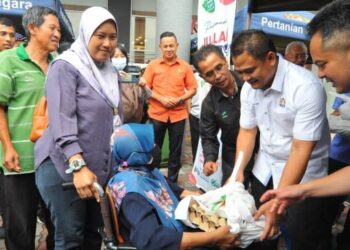 ZAHARI Sarip (dua dari kanan) menyampaikan telur dan ayam kepada salah seorang pengunjung pada jualan happy hour sempena Majlis Johor Fama Fest 2023 di AEON Bukit Indah, Johor Bahru, hari ini. UTUSAN/RAJA JAAFAR ALI