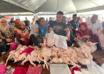 PENGUNJUNG mengambil kesempatan membeli ayam yang dijual pada harga RM6 sekilogram sempena Program Jom Masuk Kampung di Pulau Manis, Serada, Kuala Terengganu, hari ini. - UTUSAN/KAMALIZA KAMARUDDIN
