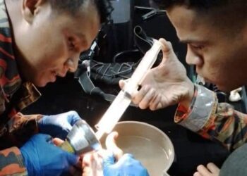 ANGGOTA bomba sedang mengeluarkan cincin besi yang tersangkut di jari telunjuk tangan kanan Muhammad Suhaimy Nordin di Balai Bomba Kuala Lipis di Lipis, Pahang.