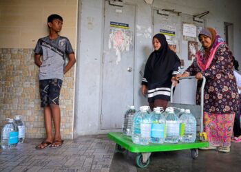 MENGUSUNG bekas berisi air yang diambil dari lori tangki setelah berjam-jam beratur di bawah panas terik adalah pemandangan lumrah di Lembah Klang. – GAMBAR HIASAN/SADDAM YUSOFF