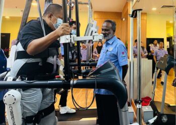 V. Sivakumar (kanan) bertanya khabar kepada seorang  penerima SKSPS yang menerima rawatan menggunakan teknologi neuro-robitik 'Cyberdyne' di Pusat Rehabilitasi Perkeso Kuala Terengganu di Hotel Permai, Kuala  Terengganu, hari ini. - UTUSAN/KAMALIZA KAMARUDDIN