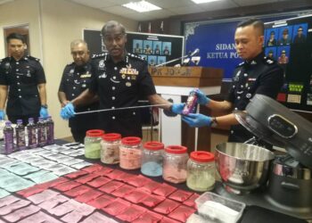 M. KUMAR menunjukkan cecair dadah yang dibungkus semula dalam botol minuman berperisa di IPK Johor, Johor Bahru.