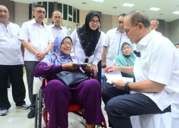 WAN ROSDY Wan Ismail (kanan) menyerahkan Kad Kesihatan kepada penerima, Siti Jamiah Abdul Kadir, 73, sempena Majlis Penyerahan Kad Kesihatan Pahang Pride Kasih 2023, di Dewan Tun Razak di Temerloh, Pahang. - FOTO/SHAIKH AHMAD RAZIF