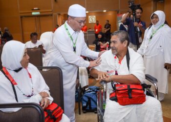 MOHD. Na'im Mokhtar menyantuni jemaah haji yang akan berlepas bersama-sama beliau ke Tanah Suci di Kompleks Haji, Sepang, Selangor. - UTUSAN/FAISOL MUSTAFA