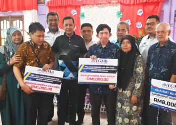 ABDUL Muie Ngah (lima, kiri) dan Wan Munadi Wan Mamat (enam, kiri) bergambar bersama penerima manfaat khairat kematian dan sumbangan khas pelajar berkeperluan Khas SPM 2022 di SMK Bukit Besar, Kuala Terengganu, hari ini. - UTUSAN/PUQTRA HAIRRY ROSLI