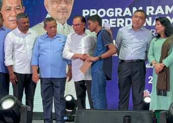 ANWAR Ibrahim menyampaikan sumbangan kepada pelajar terbaik SPM DUN Nilai pada Program Ramah Mesra Bersama Masyarakat India Setempat di Desa Cempaka, Nilai di Seremban hari ini. - UTUSAN/ZAKKINA WATI AHMAD TARMIZI