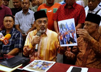 TAJUDDIN Abdul Rahman (tengah) menunjukkan bukti bergambar beliau membantu kempen PRU-15 dalam sidang akhbar di Ipoh hari ini. - UTUSAN/ZULFACHRI ZULKIFLI.