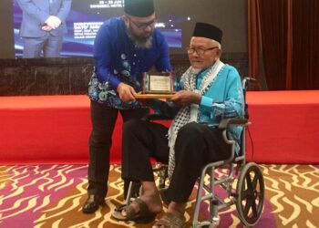 ASMADI Abdul Rahman (kiri) menyampaikan Anugerah Khidmat Setia Amil Negeri Pahang kepada antara amil yang paling lama berkhidmat iaitu Abdul Rahman Mat Jid berusia 90 tahun dari Kuala Lipis di Kuantan, Pahang. - FOTO/ DIANA SURYA ABD WAHAB