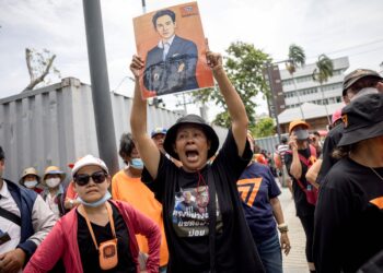 PENYOKONG MFP memegang poster Pita Limjaroenrat selepas mahkamah menggantung keahliannya dalam Parlimen buat sementara waktu. - AFP