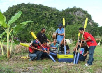 AHLI-ahli kumpulan dari Kampung Nesam bermain persembahan alu bunyi iaitu kesenian dan warisan Perlis berusia lebih 200 tahun yang terus bertahan di kawasan sawah padi berlatar belakangkan bukit di Kampung Nesam, Bintong, Kangar, Perlis, semalam.- UTUSAN/IZLIZAN OTHMAN