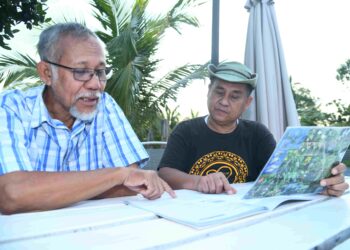 MAKETAB Mohamed (kiri) berbincang bersama Halim Ismail mengenai kajian berhubung potensi pencemaran di Empangan Timah Tasoh, Padang Besar, Perlis. – UTUSAN/IZLIZAN OTHMAN