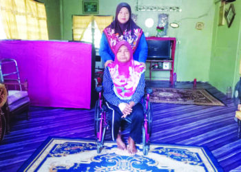 RAHIMAH A. Razak (berkerusi roda) dibantu Shuhaida untuk semua urusan kebajikan di rumah ibu bapa mereka di Felda Kota Gelanggi Dua di Jerantut, Pahang. – UTUSAN/HARIS FADILAH AHMAD