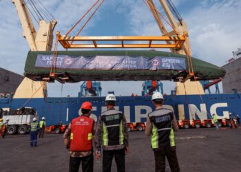 PEKERJA menurunkan kepala gerabak kereta api berkelajuan tinggi pertama dari kapal kargo di Pelabuhan Tanjung Priok di Jakarta.-AFP