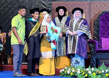 RUBIAH Wang (kanan) menyerahkan Anugerah Menteri Kemajuan Desa dan Wilayah dan Graduan Keseluruhan Terbaik Kolej Universiti Agrosains Malaysia (UCAM) kepada Mohd. Shah Shafiq Hamran yang ditemani ibu bapanya sempena Majlis Konvokesyen UCAM kali ke-20 di Universiti Sains Islam Malaysia (USIM), Nilai. –  UTUSAN/ZAKKINA WATI AHMAD TARMIZI